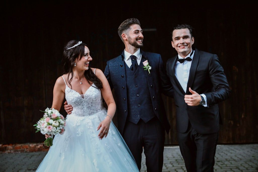 Tamada steht lachend mit dem Brautpaar zusammen bei einer deutsch-russischen Hochzeit in N&uuml;rnberg