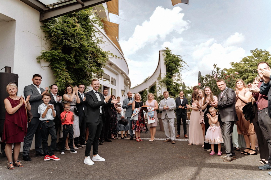 Tamada empf&auml;ngt vor der Location die applaudierenden G&auml;ste bei einer deutsch-russischen Hochzeit in N&uuml;rnberg