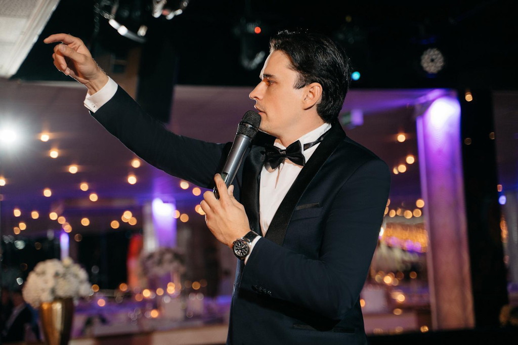 Zweisprachiger Tamada im Smoking moderiert mit Mikrofon eine deutsch-russische Hochzeit in N&uuml;rnberg